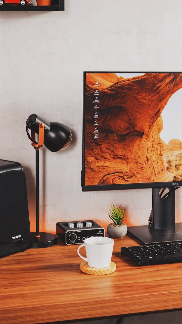 computer and a ceramic cup on wooden table